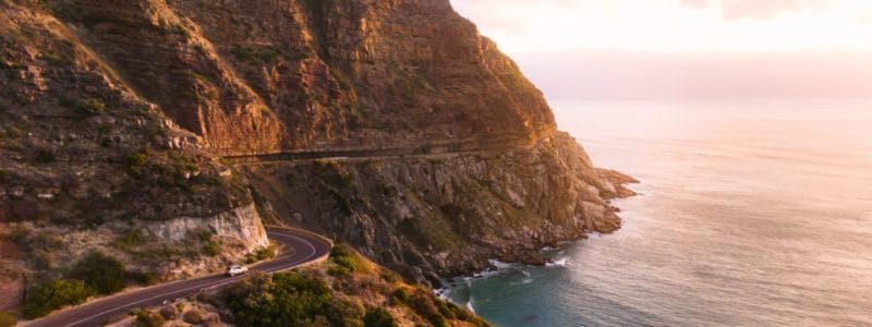 Roadtrip in beautiful landscape. Car driving on the famous Chapmans Peak Drive stretch close to Cape Town, South Africa.