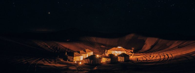 Desert camp in the endless expanse of the Sahara in Morocco at night.
