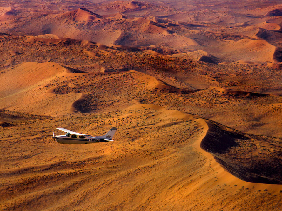 Light aircraft flying over the desert in Namibia- one of the country's in the Africa travel restrictions Coronavirus information