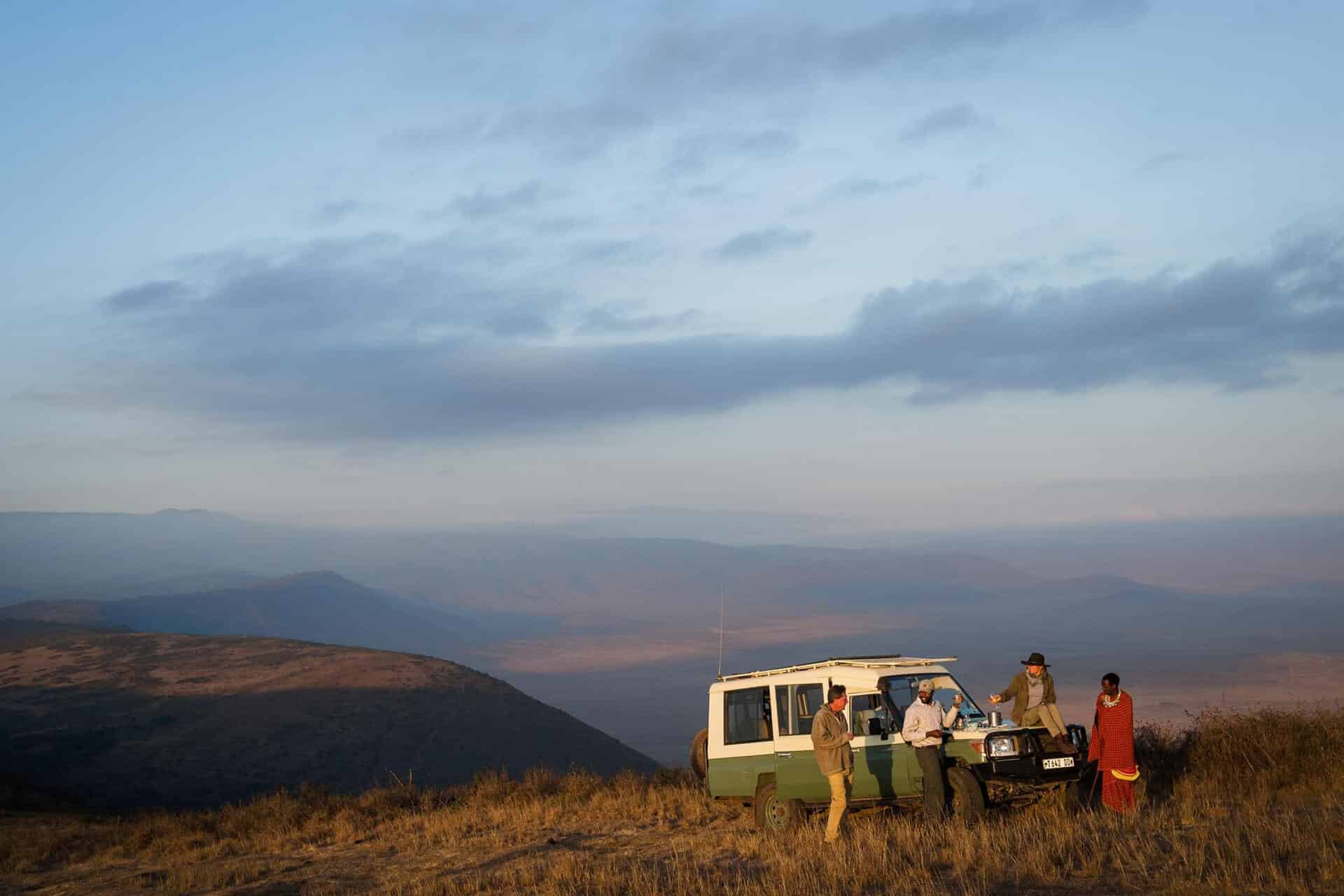 Safari vehicle with guests having a sunset drink on the crater rim