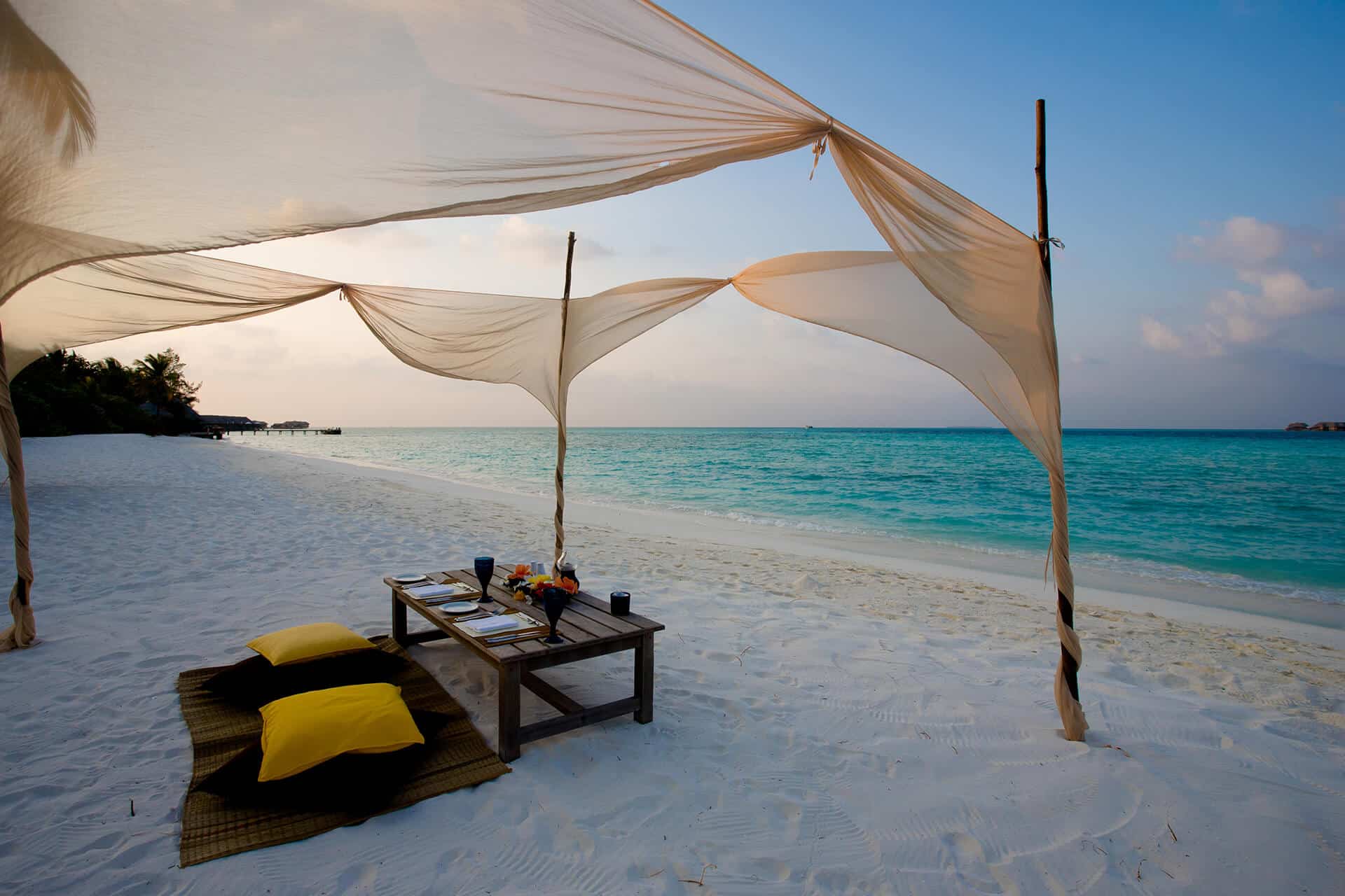 Beach front view with table and refreshments on white sands overlooking crystal clear Mauritius waters.