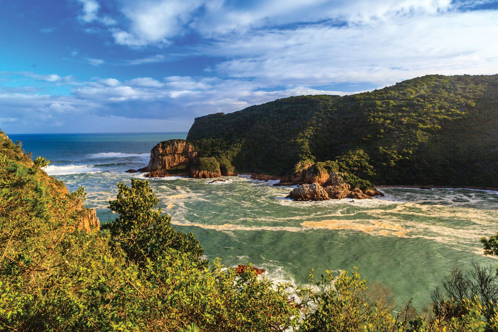 South Africa Knysna. Stunning view of two mountain coastal views surrounding incoming ocean water with clear blue South African skies above