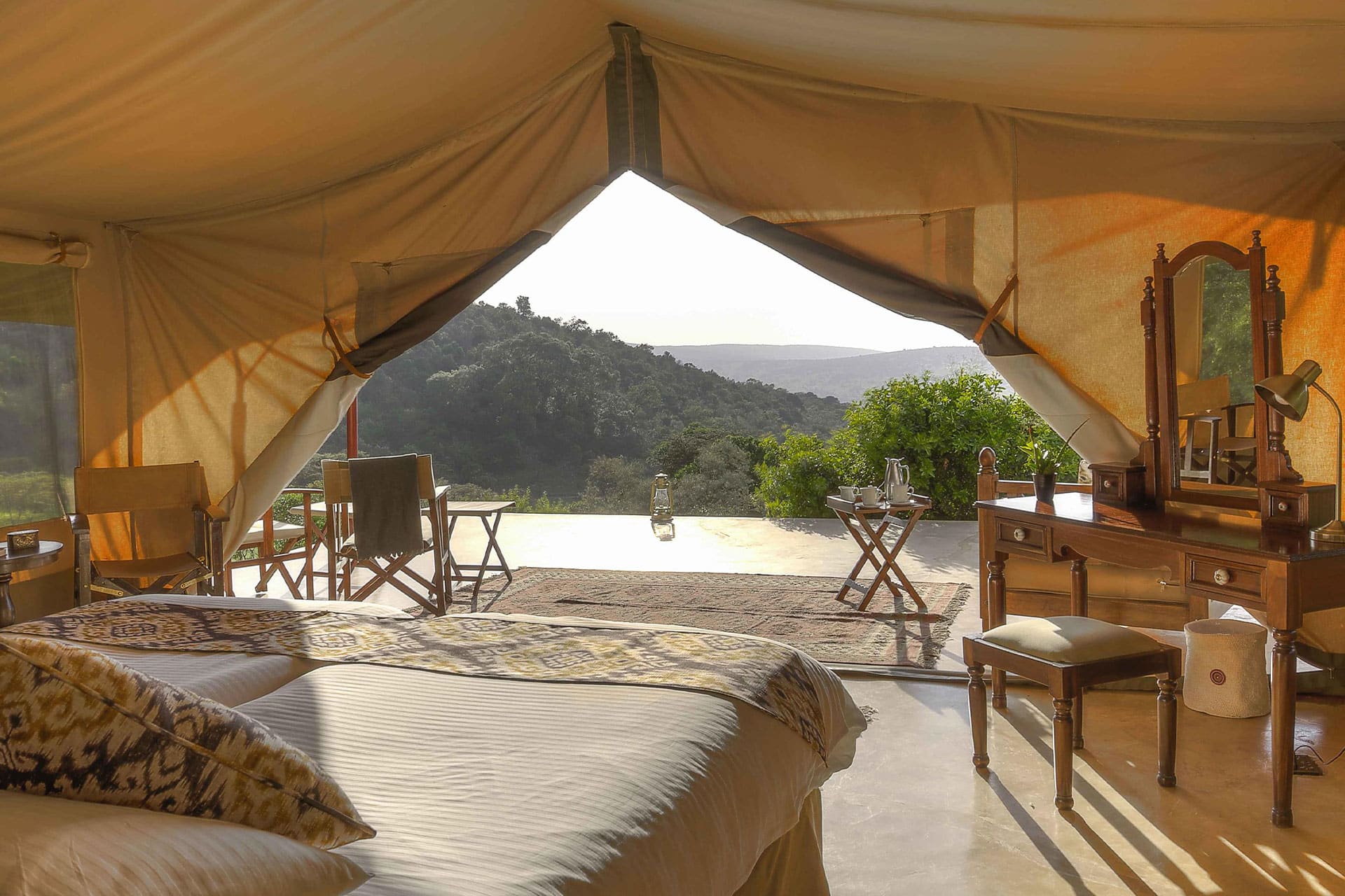 A bedroom looking out over a valley at Entumoto Safari Camp