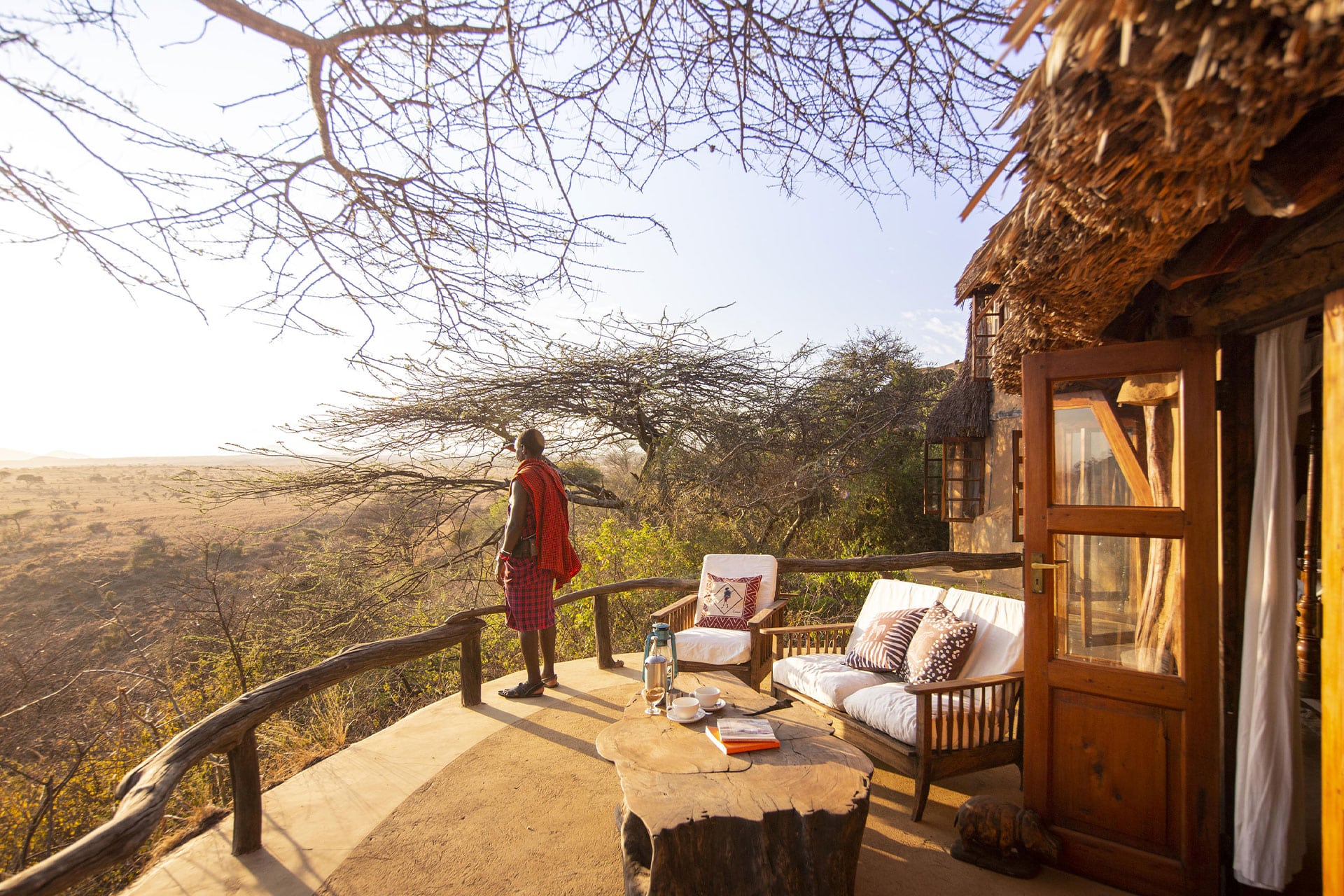 A Maasai man stands on the deck overlooking the bushveld at Lewa Wilderness