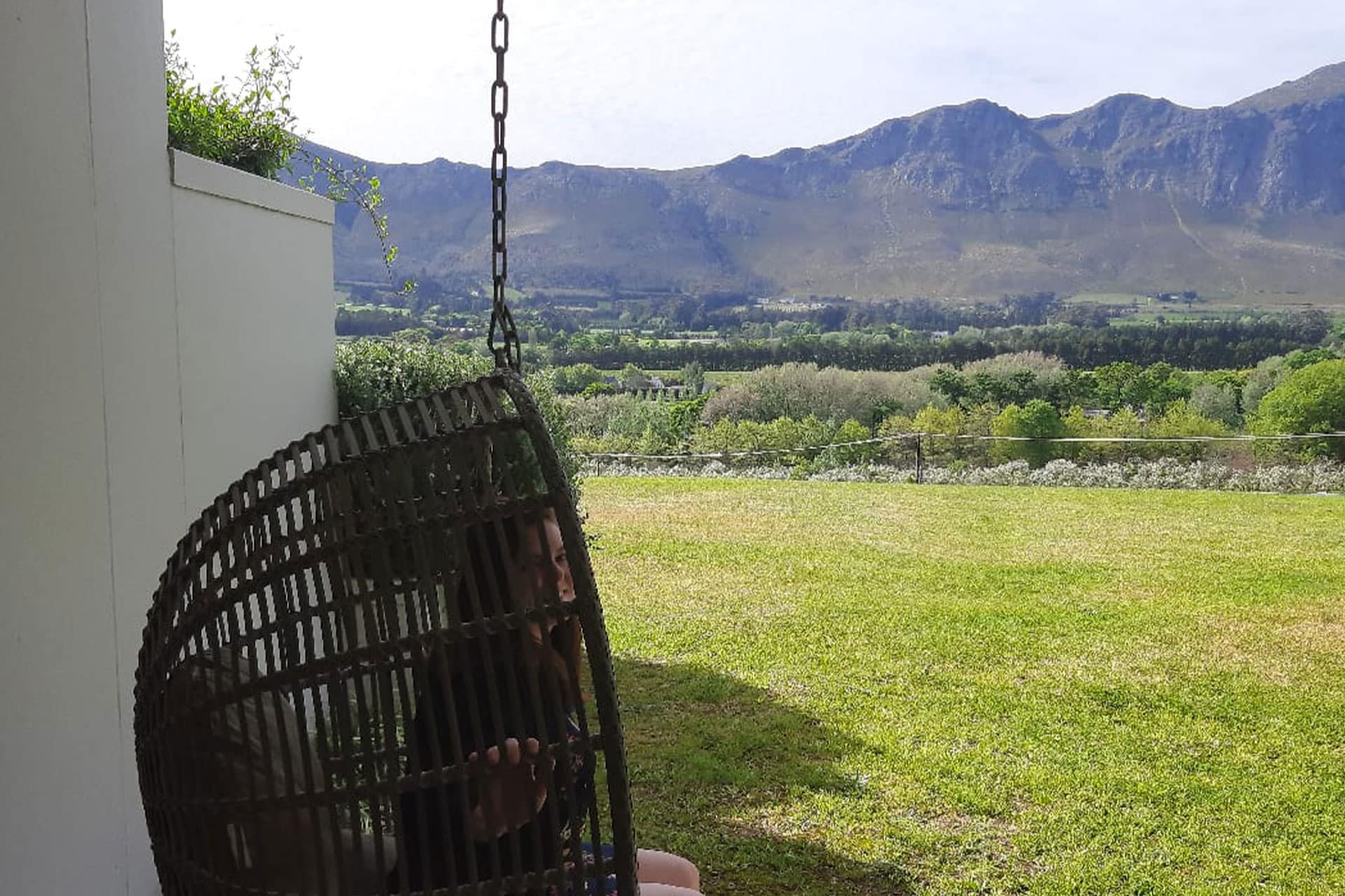 Emma Perrin sitting on a swing chair outside the cap Classique suite at Mont Rochelle