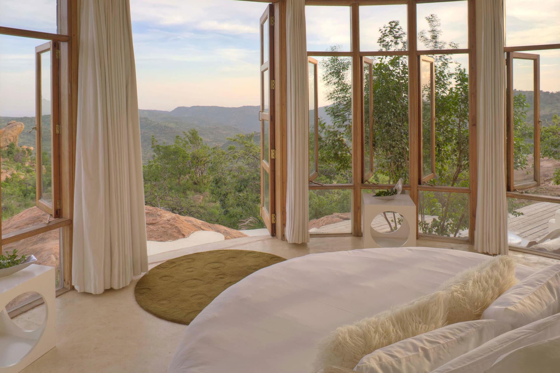 A bedroom at The Sanctuary at Ol Lentille with beautiful views of the Kenyan wilderness.