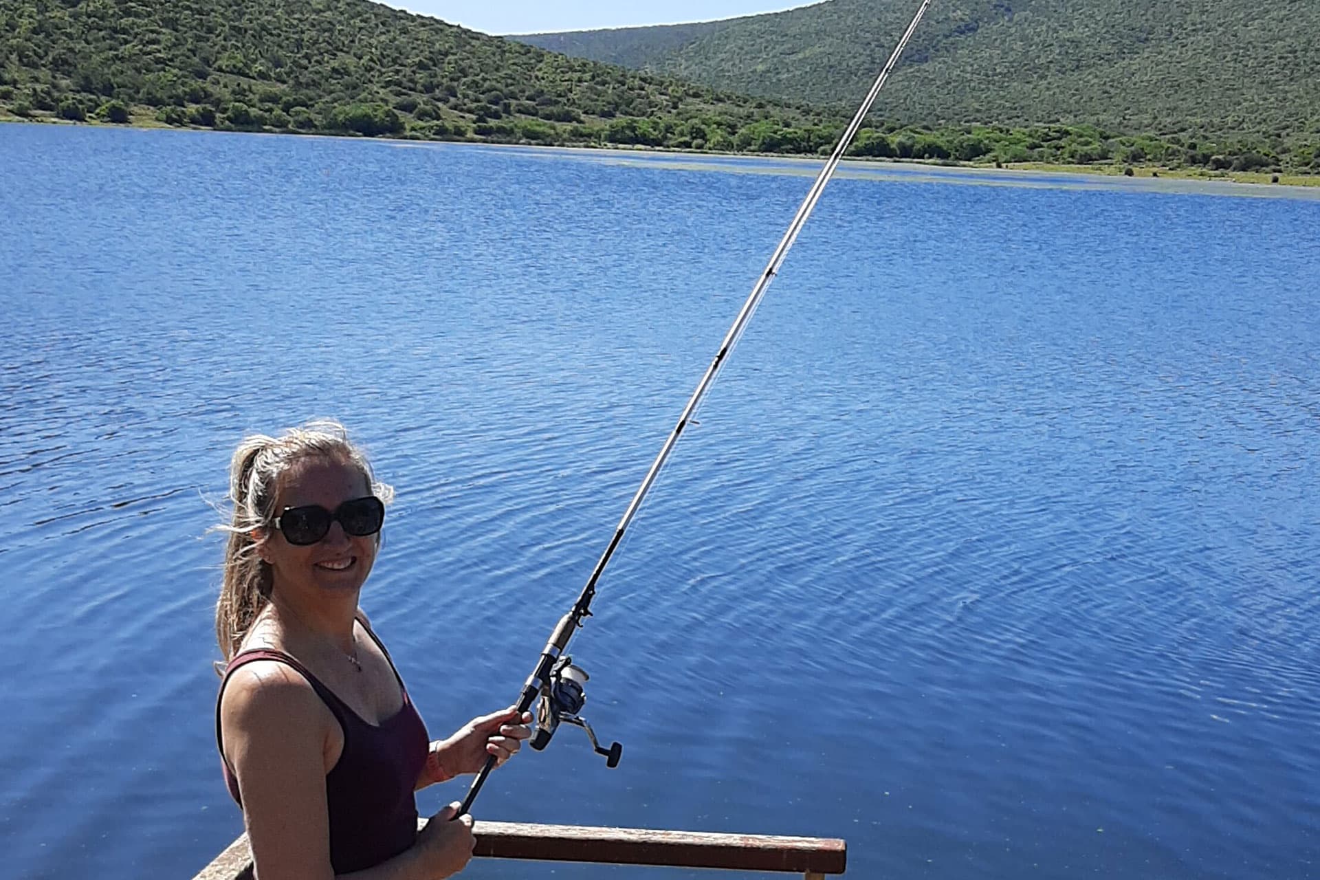 A woman fishing at Galpin Dam in Kwandwe Private Game Reserve.