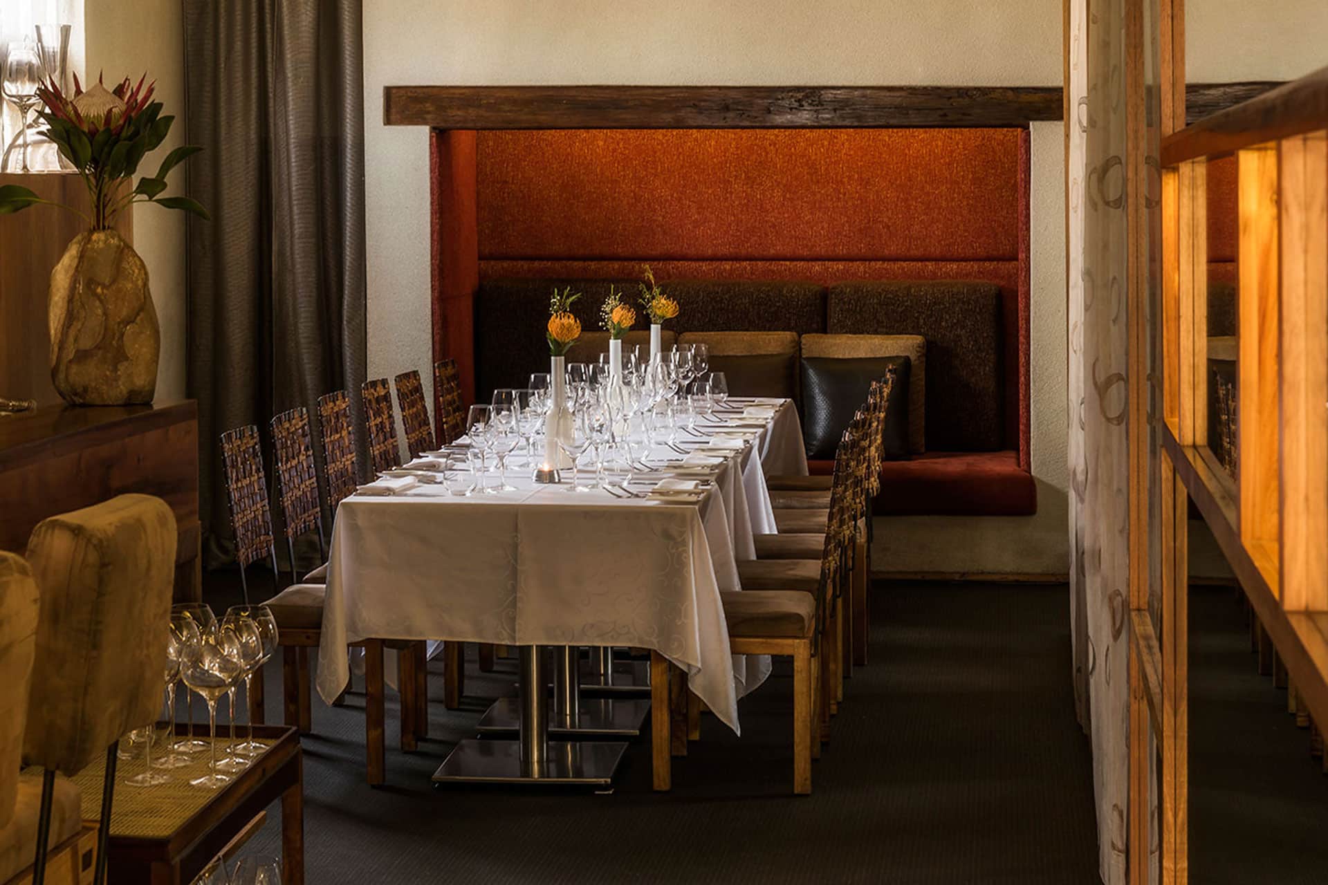 A dining table with chairs around it at Aubergine Restaurant – one of the top 10 fine dining restaurants in Cape Town.