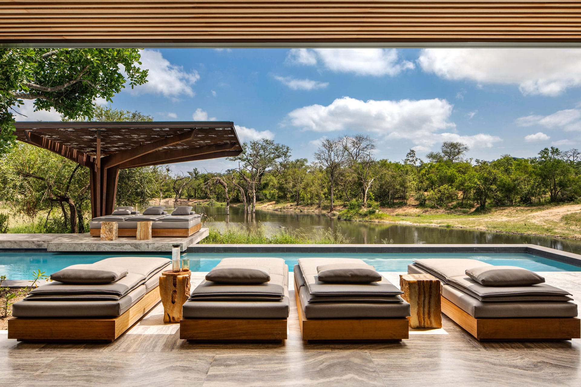 Pool and seating area on a deck with a view of the river at a villa at Cheetah Plains in the Sabi Sands Game Reserve.