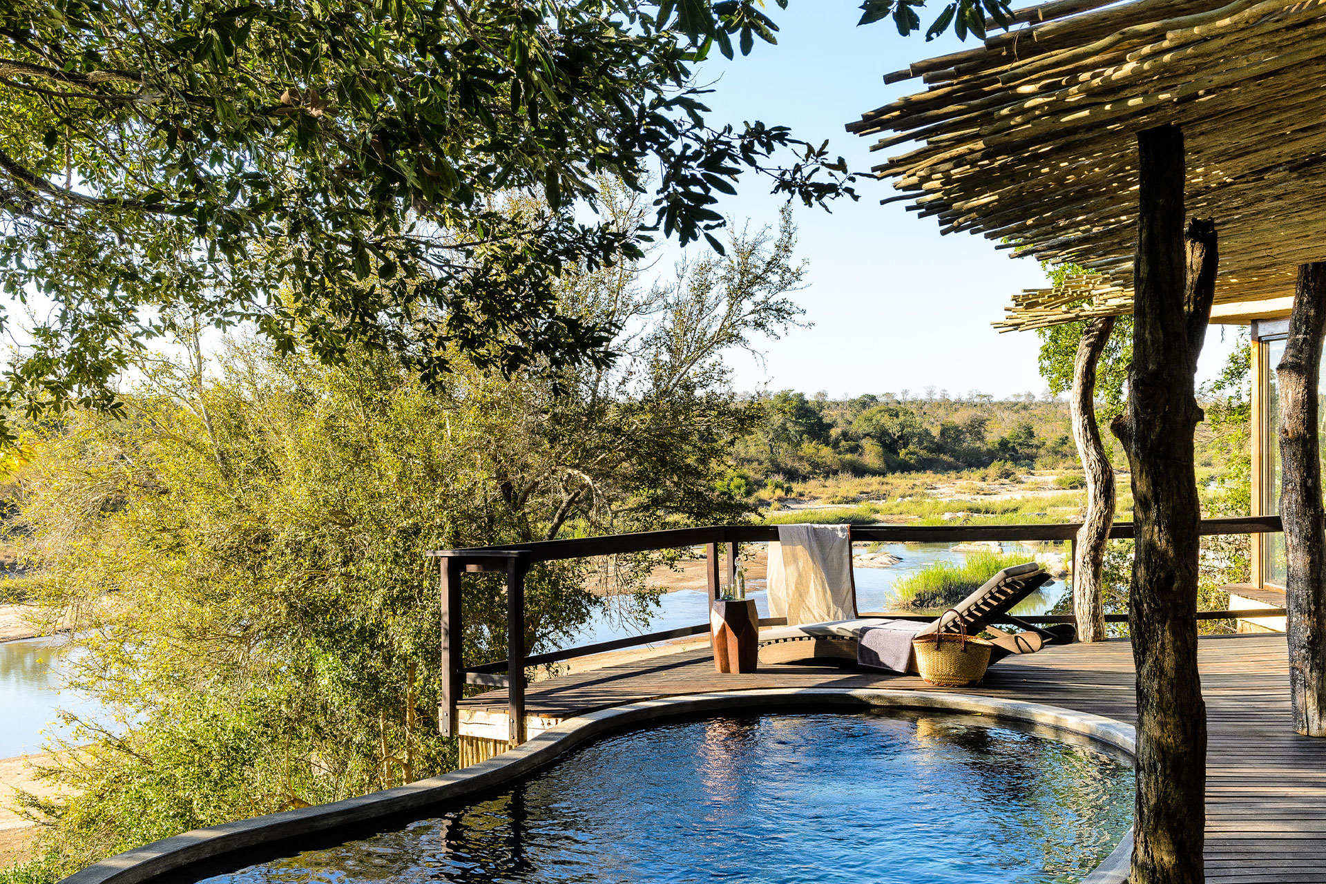A swimming pool with views of the Sand River at Singita Boulders Lodge.