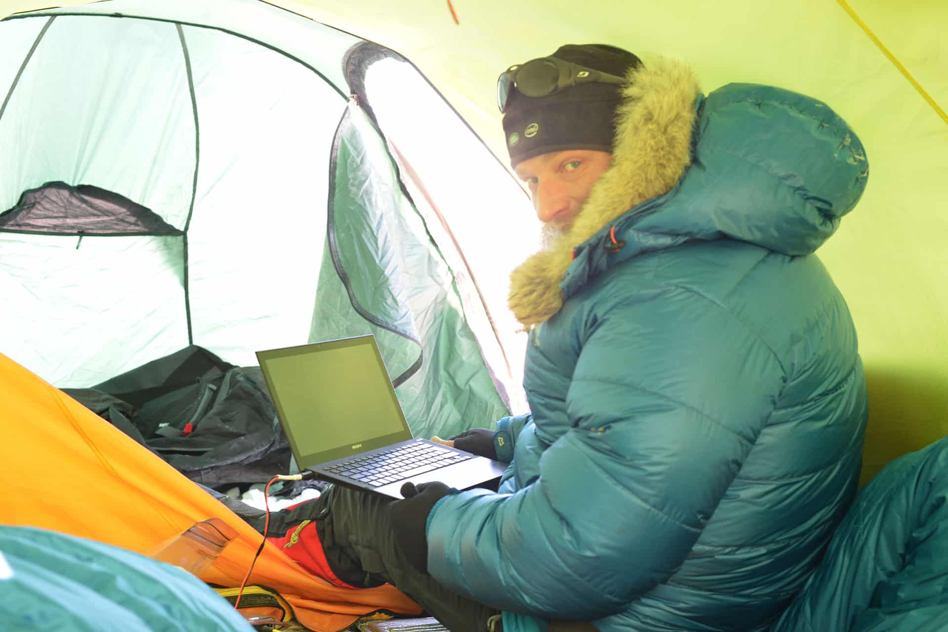 Ben Saunders in a tent with a laptop in Antarctica.
