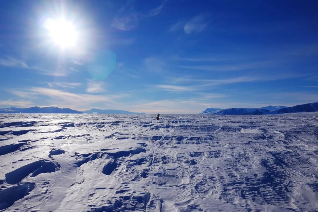 Adventurer Ben Saunders walking solo across vast Antarctic ice under a bright polar sun during an extreme expedition