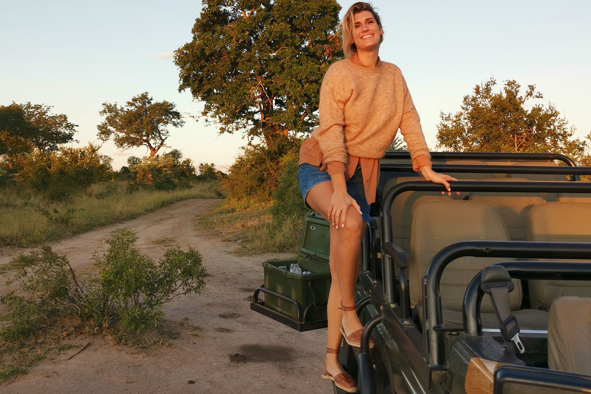 General Manager of Ker & Downey® Africa’s France DMC, Cynthia Deneux, posing next to a safari game vehicle at Thornybush, South Africa.
