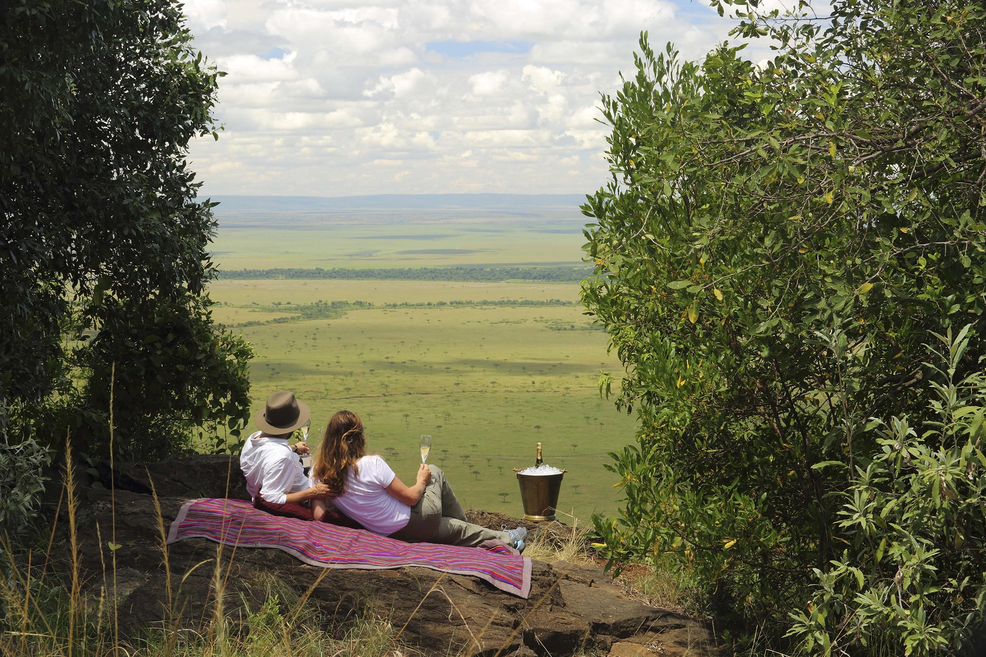 A couple having a picnic in the Maasai Mara – a recommended destination for honeymoons in Africa.