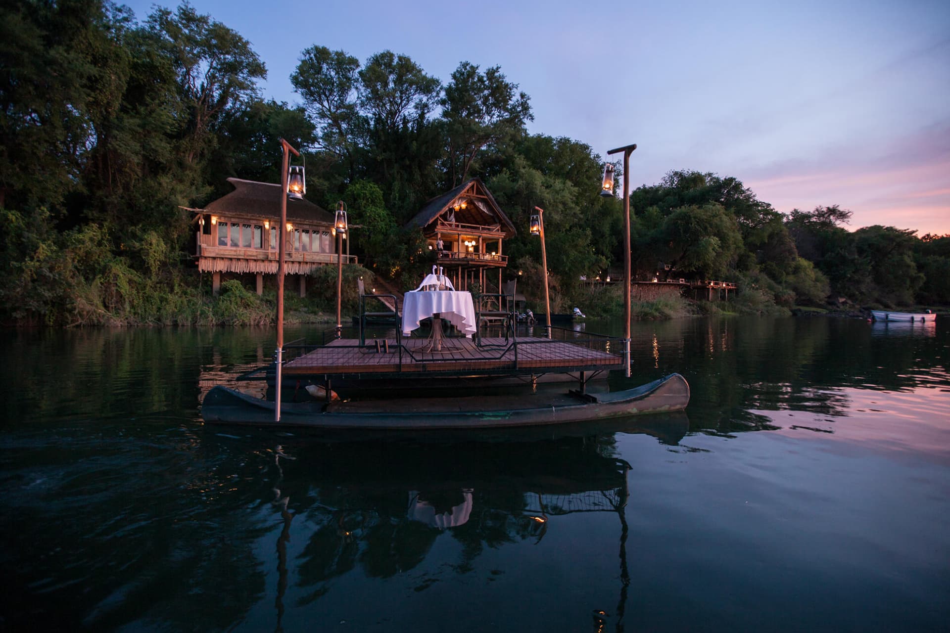 Dinner set up on a sampan on the Zambezi River at Tongabezi – a recommended destination for honeymoons in Africa