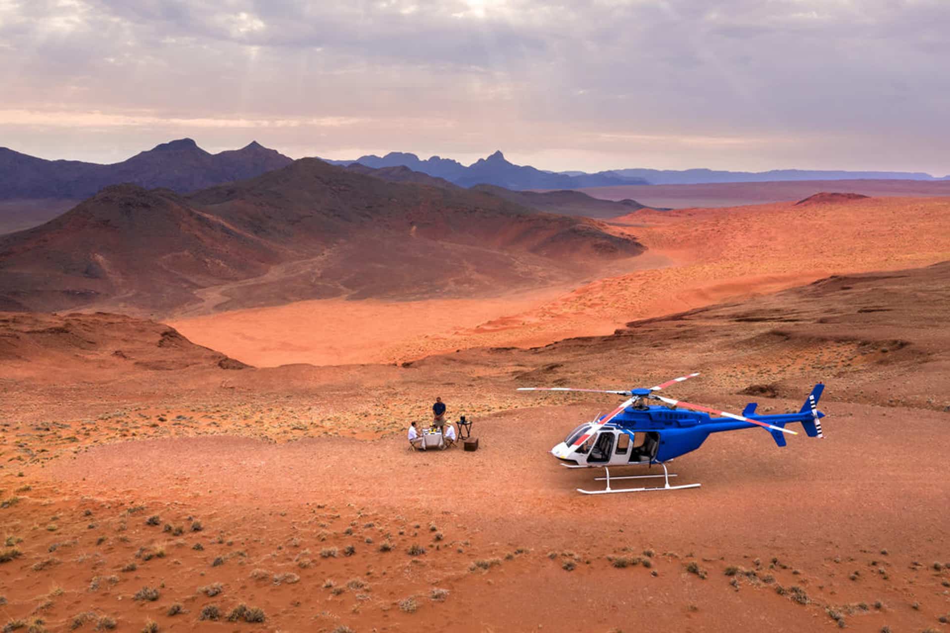 A romantic champagne picnic during a scenic helicopter flip over the desert – a recommended experience for honeymoons in Africa.