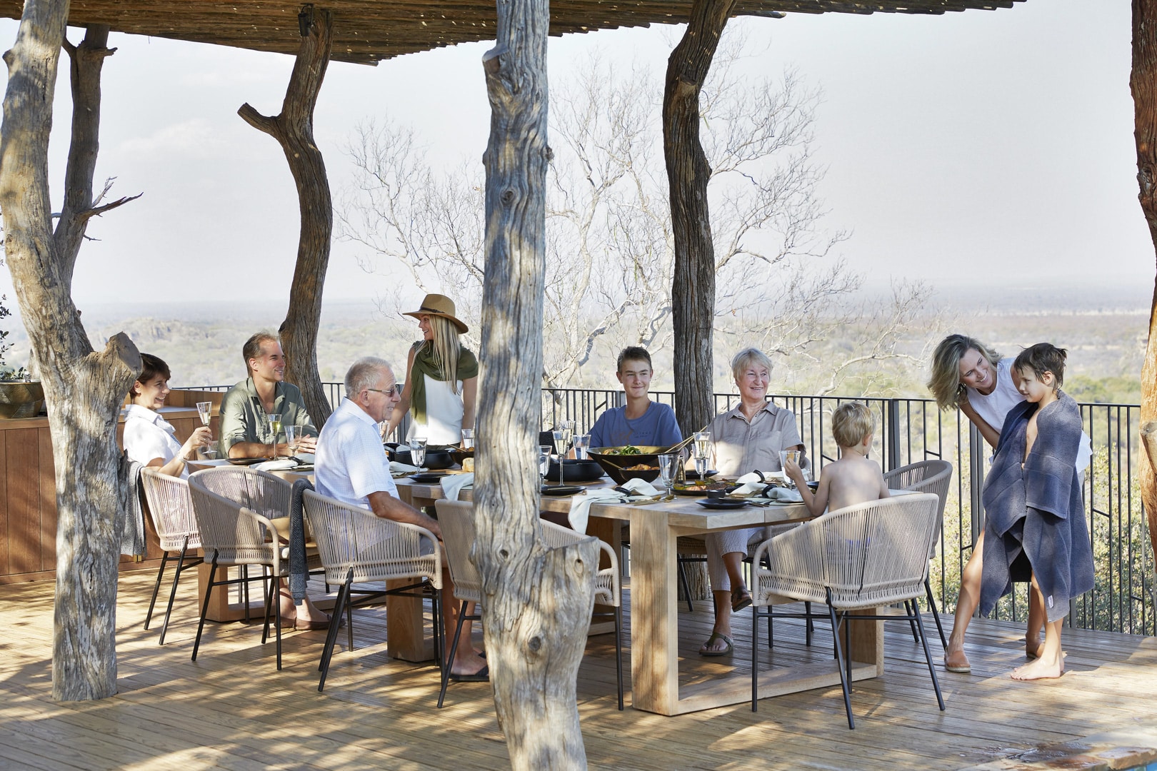 A family dining on the deck at Singita Malilangwe House – one of Southern Africa’s best family friendly lodges.
