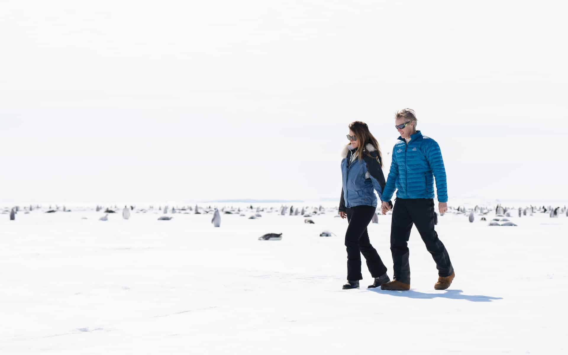 Patrick Woodhead in Antarctica walking holding his wife Robyn’s hand.