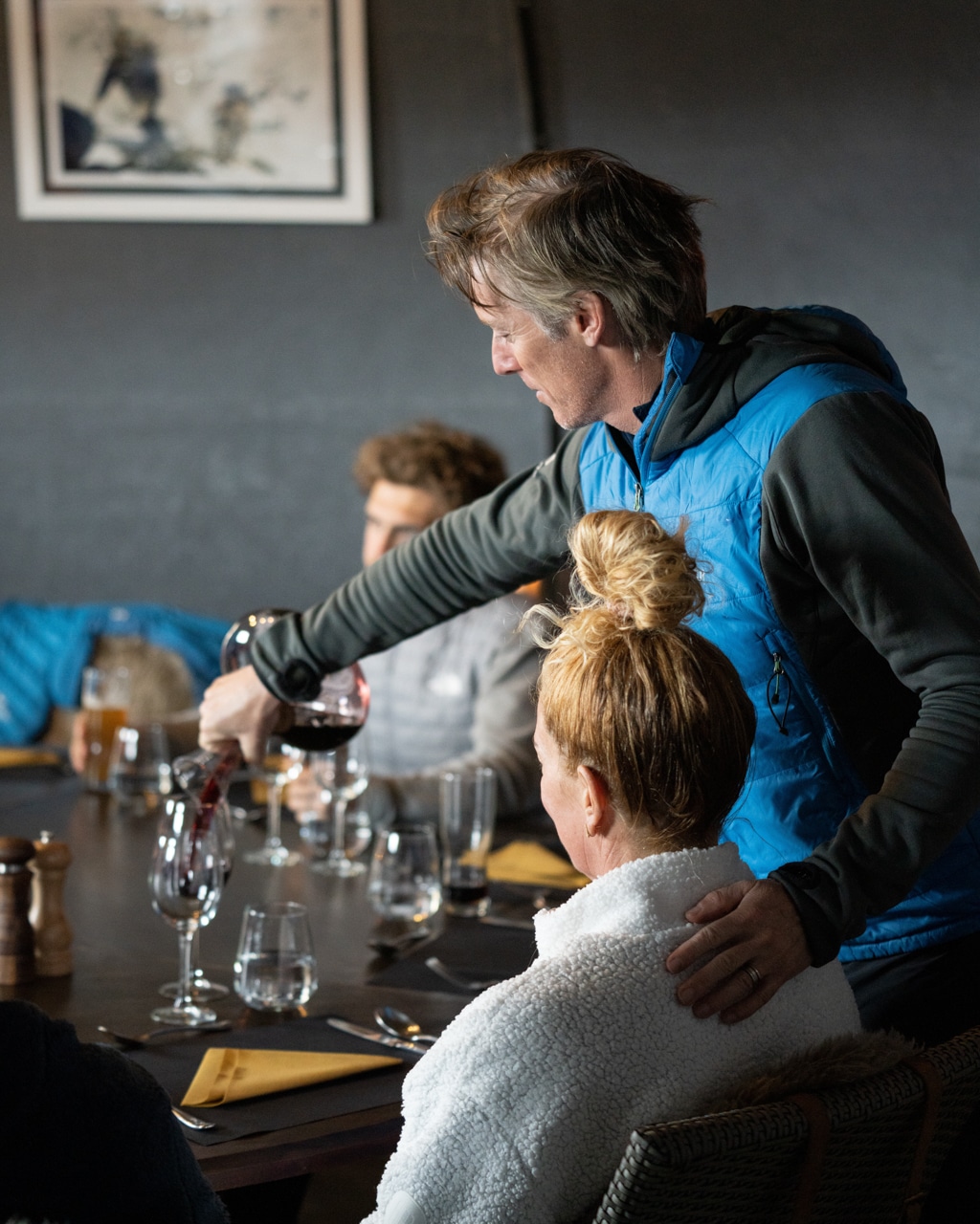 Patrick Woodhead pouring a glass of wine for a guest at Whichaway Camp in Antarctica.