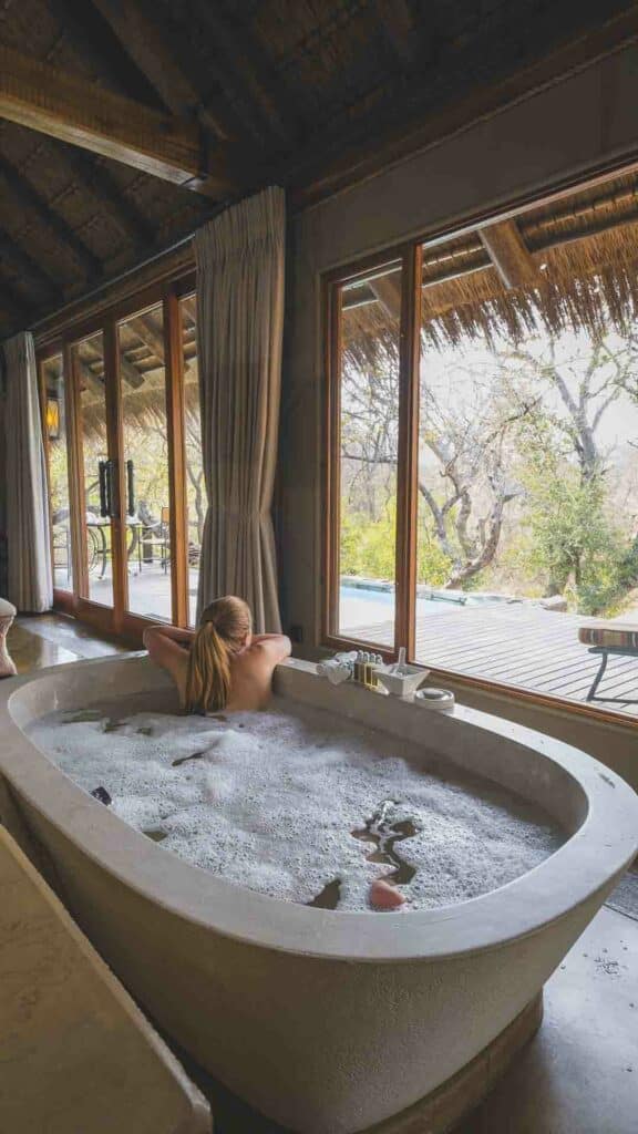 A woman in the stone bath in a superior suite at Jabulani Safari lodge.
