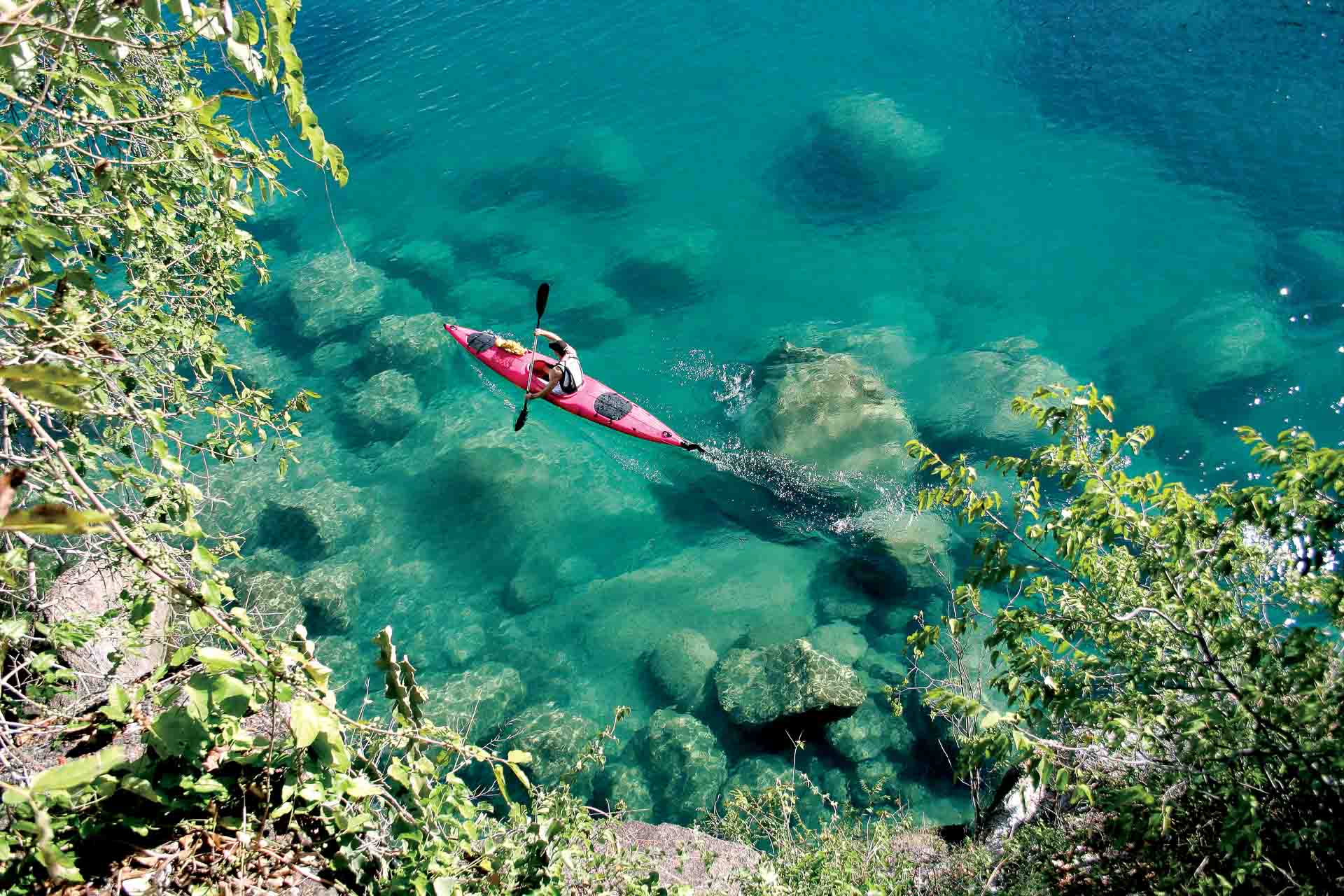 Marine safaris Lake Malawi kayaking through clear blue waters. Luxury African safari.