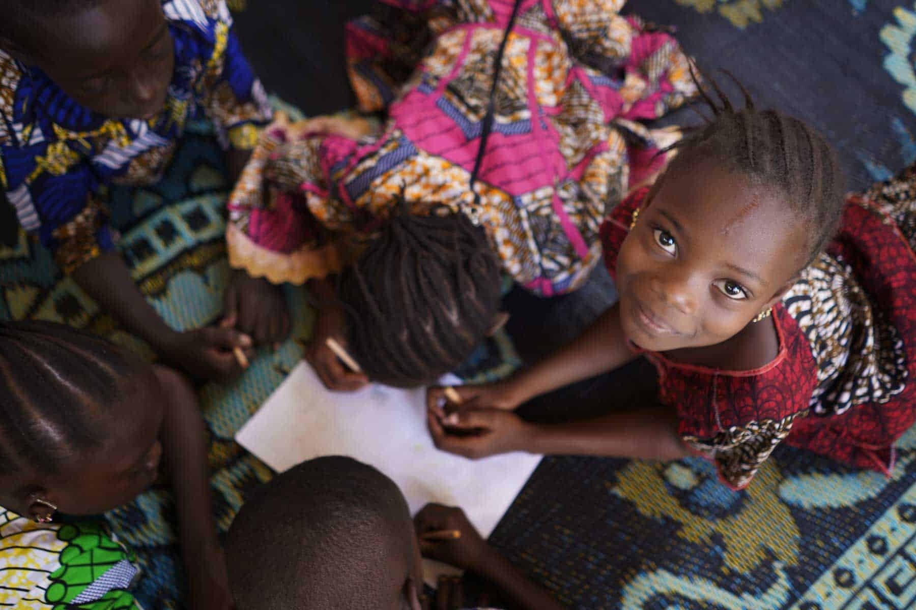 OKOA Fund Group of African black children working with paper and drawing