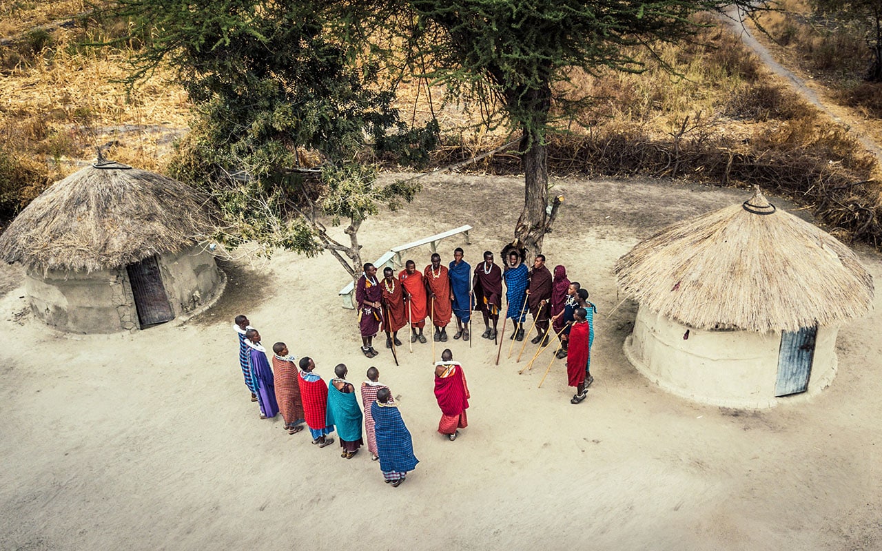 Maasai people standing inside their traditional boma with Ker & Downey® Africa
