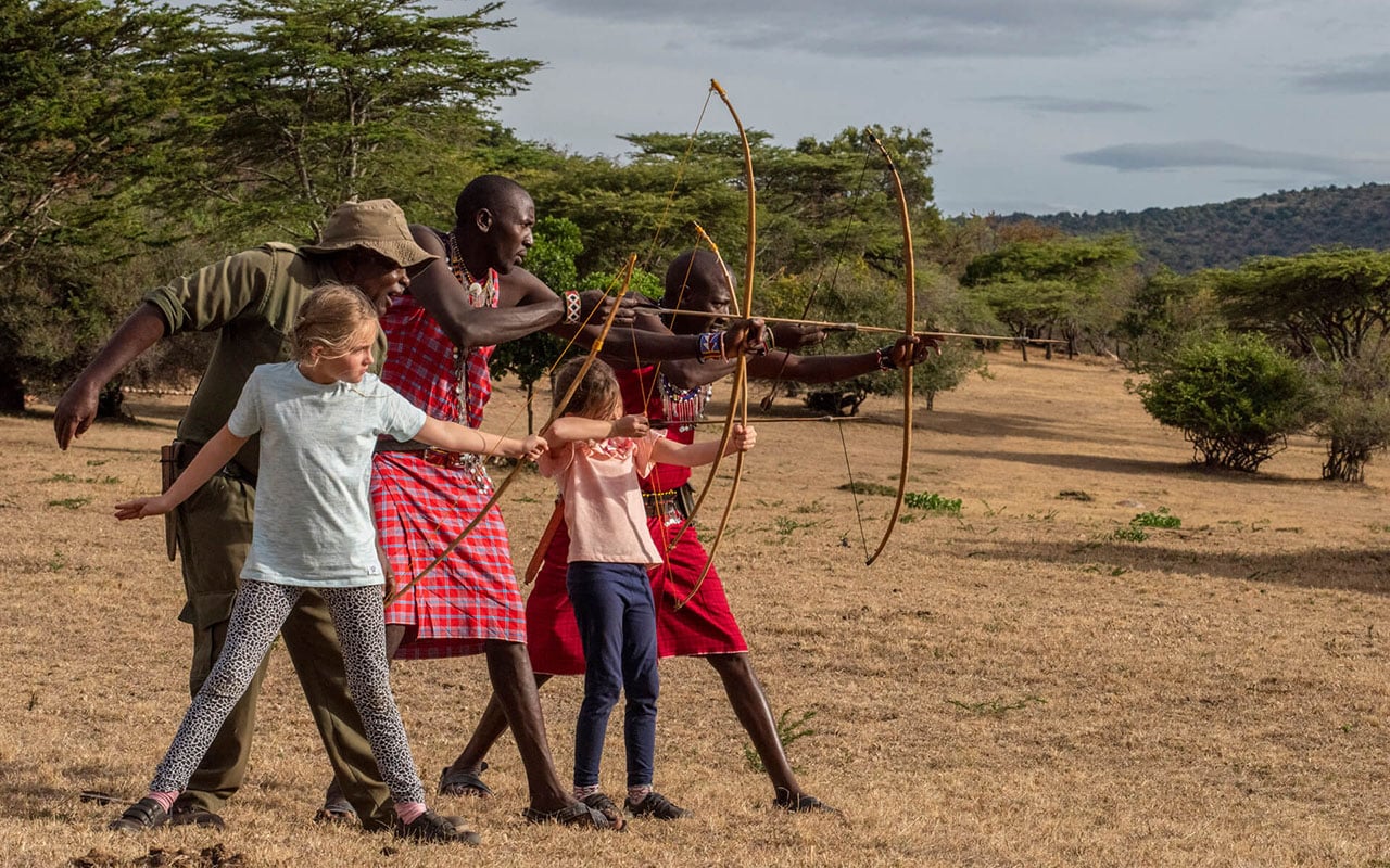 Kids and Maasai with bow and arrows at Cottar’s Safari with Ker & Downey® Africa