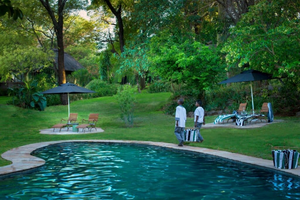 the guest pool area with a sparkling blue pool at Stanley & Livingstone Boutique Hotel