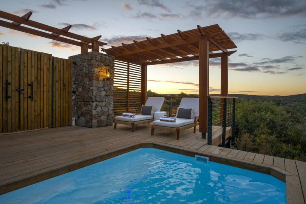 heated safari pool with a wooden deck around it at Sindile Lodge, Shamwari with Ker & Downey Africa
