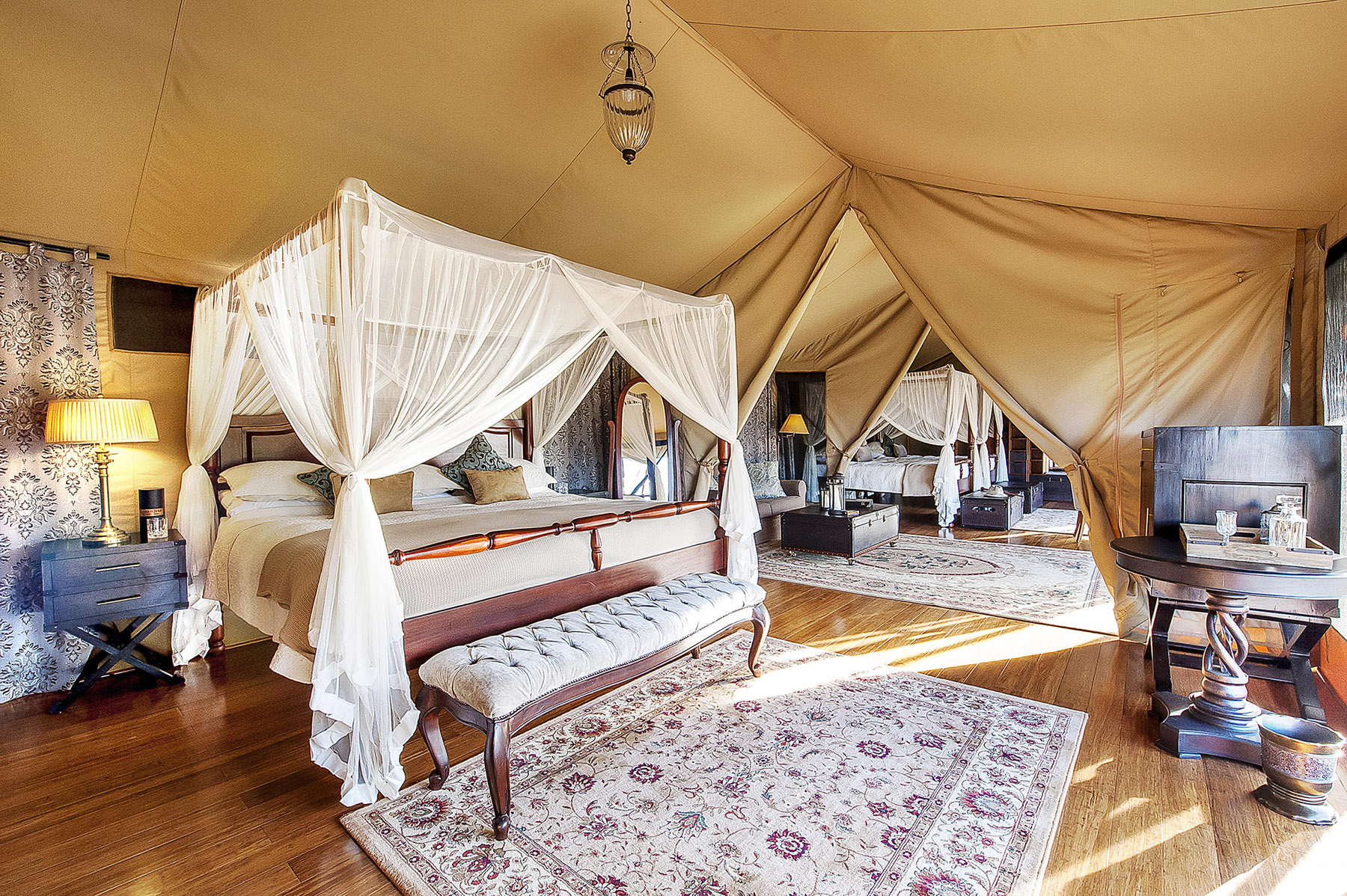 The beds inside a family tent at Elewana Sand River Mara, with Ker & Downey Africa