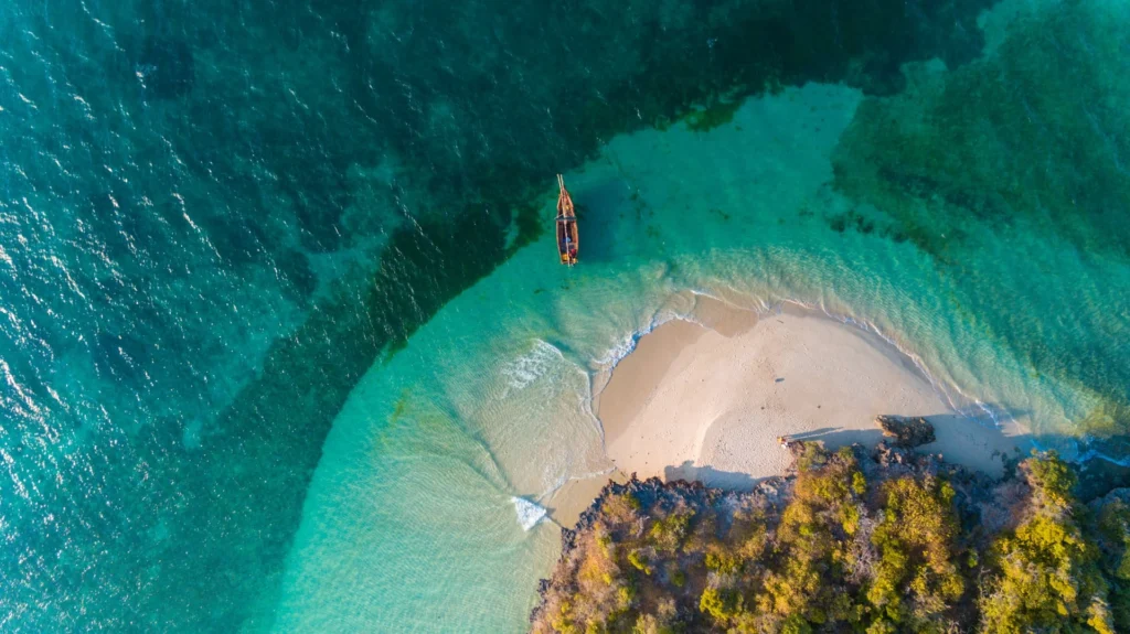 Zanzibar Resorts Fumba Island, Zanzibar. White sands coast, boat going into turquoise ocean African safari.