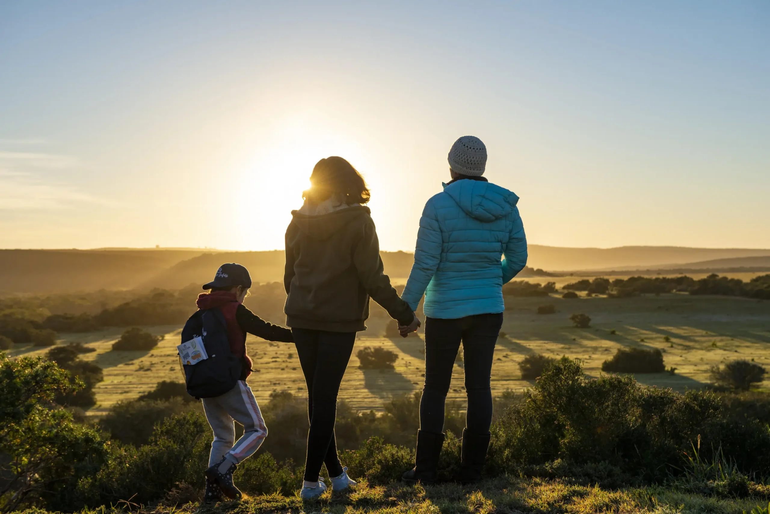 A lxury Family safari in Kenya with young kids watching sunrise over the African savannah, multigenerational travel moment in a wildlife reserve