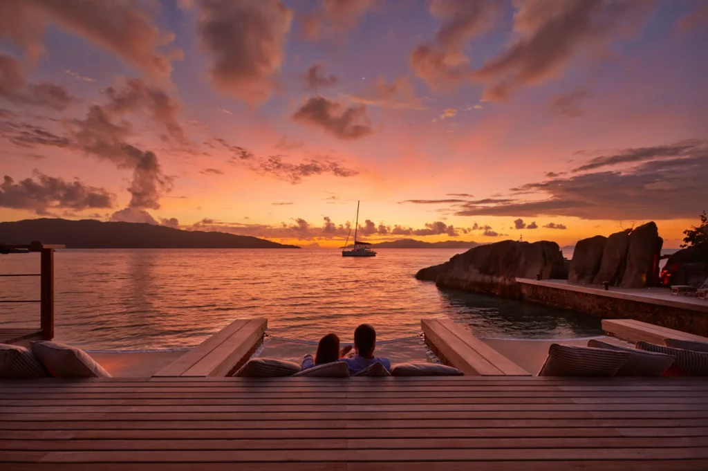 Couple relaxing on a private deck at sunset overlooking the ocean during Luxury safaris by sea Africa experience