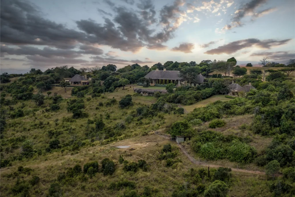 Aerial view of The Hide luxury lodge with surrounding African bush, private villas, and a central lodge building set within a wildlife reserve