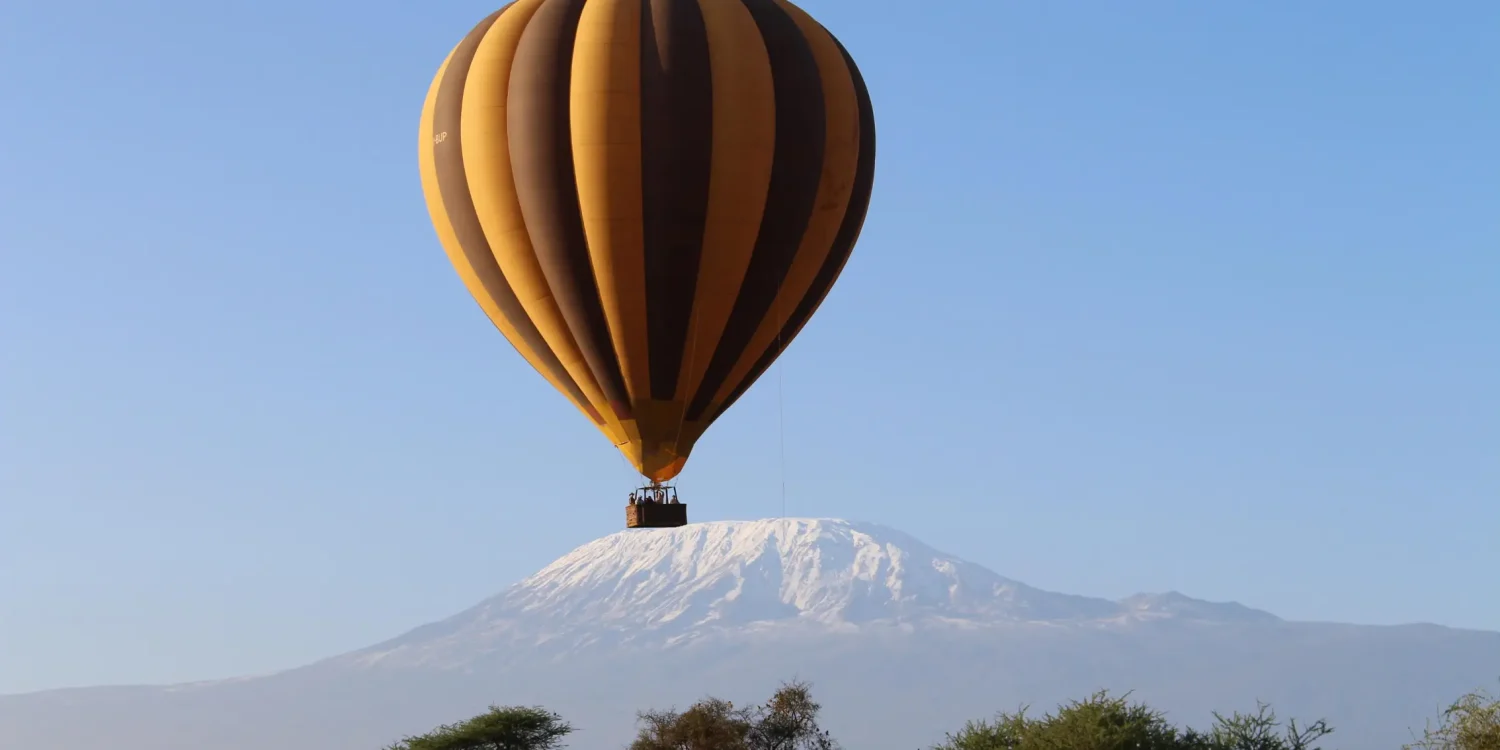 Luxury safaris by air Africa hot air balloon floating above Mount Kilimanjaro at sunrise on an exclusive safari journey
