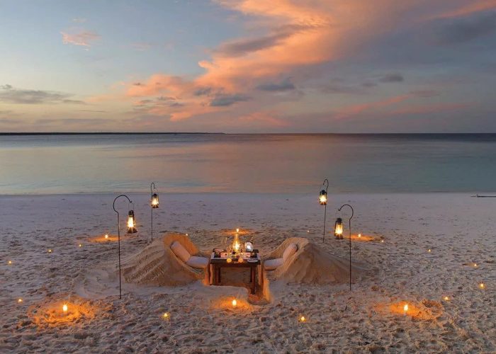 Mnemba Island Zanzibar. White sands with picnic table looking out to African sunset and ocean. African safari.