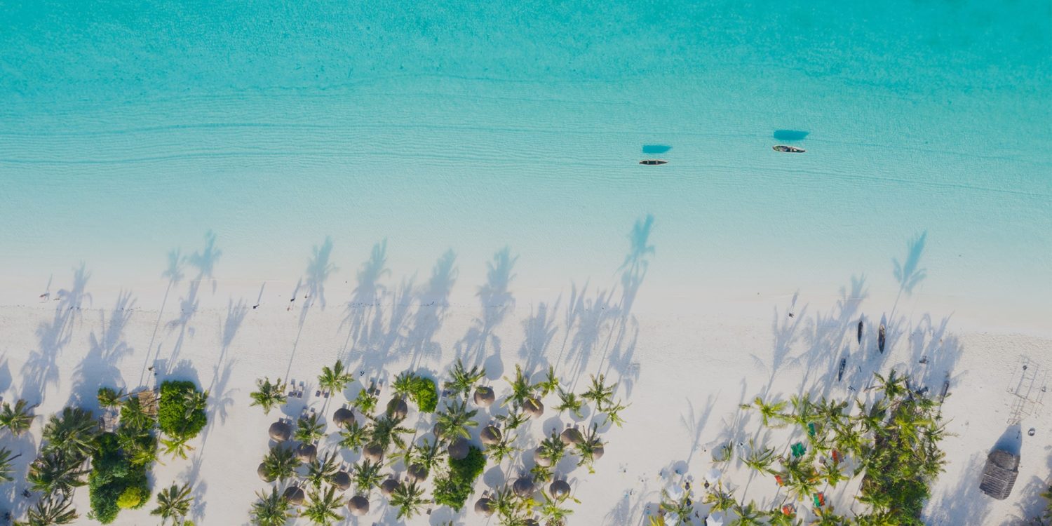 Luxury turquoise waters of Zanzibar, the best destination for a high-end family holiday. Arial view of white sand beach with turquoise waters. Luxury beach resort in Zanzibar with white sand and turquoise ocean water.